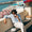 Uomo seduto vista mare in Costiera Amalfitana con camicia in 100% lino e pantaloni bianchi in cotone, mentre mangia un gelato.